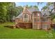 Expansive brick home with a large lawn, patio, and lush green landscaping at 130 Stonewall Beach Ln, Mooresville, NC 28117