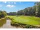 Lush golf course featuring pristine green lawns, water features, and mature trees in a serene and picturesque setting at 130 Stonewall Beach Ln, Mooresville, NC 28117