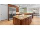 Kitchen showcasing stainless steel refrigerator, expansive granite island, and abundant natural light at 130 Stonewall Beach Ln, Mooresville, NC 28117