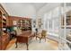 Home office with custom built-ins, a large window, and a classic wooden desk at 130 Stonewall Beach Ln, Mooresville, NC 28117