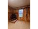 Room with wood paneling, brick fireplace, and wood stove at 1409 Trinity Church Rd, Monroe, NC 28112