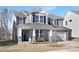 Two-story house with gray siding, stone accents, and a two-car garage at 2040 White Cypress Ct # Kh09, Charlotte, NC 28216