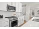 Modern kitchen features white cabinets, stainless steel appliances, and herringbone backsplash at 2040 White Cypress Ct # Kh09, Charlotte, NC 28216