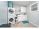 Bright laundry room with washer, dryer, cabinets, and sink at 121 Canvasback Rd, Mooresville, NC 28117