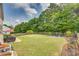 Expansive backyard featuring a patio, picnic table, fire pit, and well-maintained lawn with lush trees at 16840 Rudence Ct, Charlotte, NC 28278