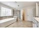 Bright bathroom featuring tile floors, a tub, and a separate glass-door shower at 16840 Rudence Ct, Charlotte, NC 28278