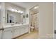 Bright bathroom with a double sink vanity and decorative accents, plus a toilet in a separate alcove at 16840 Rudence Ct, Charlotte, NC 28278