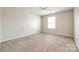 Bright bedroom with a ceiling fan, neutral carpet, and a bright window at 16840 Rudence Ct, Charlotte, NC 28278