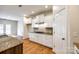 Bright kitchen features granite countertops, white cabinets, stainless hood, and a wood floor at 16840 Rudence Ct, Charlotte, NC 28278