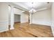 Open-concept living room with hardwood floors, columns, and a chandelier at 16840 Rudence Ct, Charlotte, NC 28278