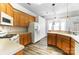 Bright eat-in kitchen features white appliances, wood cabinets and hardwood floors at 416 Linsbury Ct, Gastonia, NC 28056