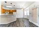 A bright kitchen features wood cabinets, modern appliances, a tiled breakfast bar, and hardwood floors at 416 Linsbury Ct, Gastonia, NC 28056