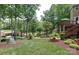 Lush backyard with mature trees, landscaping, outdoor stairs, and a lake view at 156 Marietta Rd, Mooresville, NC 28117