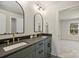 Bathroom featuring double sinks, black countertops, and stylish mirrors at 2621 Ritz Ln, Matthews, NC 28105