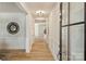 Bright hallway featuring wood floors, white wainscoting, modern lighting, and a decorative mirror at 2621 Ritz Ln, Matthews, NC 28105