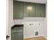 Laundry room with modern green cabinets, granite countertop, and hardwood floors at 2621 Ritz Ln, Matthews, NC 28105