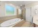 Bright bathroom showcasing a soaking tub, walk-in shower, tile flooring, and a large window at 4145 Cindy Ln, Denver, NC 28037