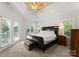 Primary bedroom with trey ceilings and an abundance of natural light from the window and french doors at 4145 Cindy Ln, Denver, NC 28037