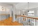 Open hallway featuring wood floors, a decorative railing, and views of the downstairs living area at 4145 Cindy Ln, Denver, NC 28037