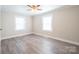 Bright bedroom with wood-look floors and two large windows at 83 Woodsdale Se Pl, Concord, NC 28025