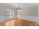 Bright dining room features hardwood floors, wainscoting, and plantation shutters at 9826 Edinburgh Ln # 282, Charlotte, NC 28269