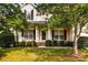 Two-story house with a front porch, mature trees, and well-manicured lawn at 9826 Edinburgh Ln # 282, Charlotte, NC 28269