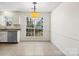 The dining area features neutral tile flooring, a large window, and classic trim at 10423 Brawley Ln, Charlotte, NC 28215