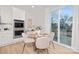 Eat-in kitchen with glass-top table, white cabinets, and sliding door to patio at 2036 White Cypress Ct # Kh10, Charlotte, NC 28216