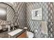 Stylish powder room with leaf-patterned wallpaper, round mirror, and granite countertop at 215 N Pine St # 3705, Charlotte, NC 28202