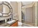 Modern bathroom with granite countertop, decorative mirror, toilet and glass enclosed shower at 215 N Pine St # 3705, Charlotte, NC 28202