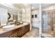 Bathroom featuring double sinks, a large mirror, and a glass-enclosed shower at 215 N Pine St # 3705, Charlotte, NC 28202