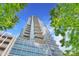 Modern condominium building featuring glass facade, multiple balconies, and green trees at 215 N Pine St # 3705, Charlotte, NC 28202