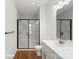 Bright bathroom featuring a glass-enclosed shower, white vanity, and wood-look flooring at 5840 Pittmon Ln, Kannapolis, NC 28081