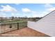 Wood-look tiled balcony with black metal railing overlooks backyard area under a cloudy sky at 5850 Pittmon Ln, Kannapolis, NC 28081