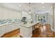 Open kitchen with white cabinetry, a large island, and hardwood floors at 13824 Claysparrow Rd, Charlotte, NC 28278