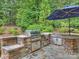 Stone outdoor kitchen with built-in grill and sink at 13824 Claysparrow Rd, Charlotte, NC 28278