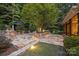 Stone patio with outdoor kitchen and built-in seating at 13824 Claysparrow Rd, Charlotte, NC 28278