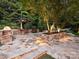 Stone patio with outdoor kitchen and built-in seating at 13824 Claysparrow Rd, Charlotte, NC 28278