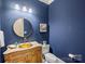 Elegant powder room with a gold vessel sink and dark blue walls at 13824 Claysparrow Rd, Charlotte, NC 28278