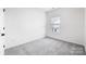 An empty bedroom with gray carpet, white walls, and a window at 1609 Blanche St, Charlotte, NC 28262