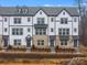 New construction townhomes with brick accents, gray roof, black wrought iron fence, and modern architectural details at 1609 Blanche St, Charlotte, NC 28262