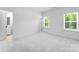 Bedroom with neutral carpet, trim, two windows and an ensuite bathroom at 5735 Allburn Pkwy, Concord, NC 28027