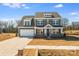 New construction with a gray color scheme, stone accents, and three-car garage at 5735 Allburn Pkwy, Concord, NC 28027