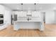 Bright, all-white kitchen features stainless steel appliances and a large center island at 5735 Allburn Pkwy, Concord, NC 28027