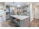 Modern kitchen with gray cabinetry, large island, and stainless steel appliances at 13050 Regent Grove Ln, Huntersville, NC 28078