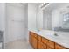 Double vanity bathroom with wood cabinets and tiled shower at 11434 Lamoille Ln, Charlotte, NC 28278