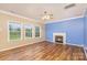 Living room with hardwood floors, fireplace, and large windows at 11434 Lamoille Ln, Charlotte, NC 28278