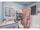 Small bathroom with shower, sink, and shelving unit at 317 Kerr Nw St, Concord, NC 28025