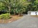 View of house, driveway, and two car garage surrounded by mature trees at 331 Sunderland Rd, Belmont, NC 28012