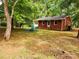 Charming brick ranch home featuring a cozy front yard sitting area and mature trees at 331 Sunderland Rd, Belmont, NC 28012